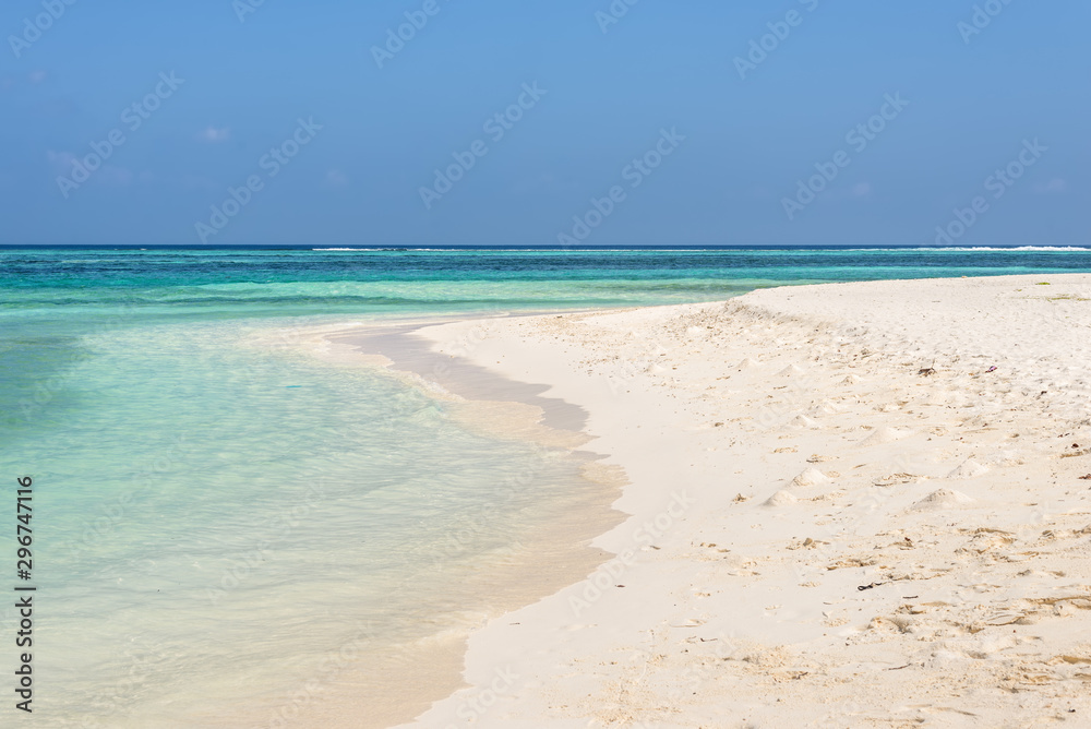 Amazing empty wild beach with turquoise water and white sand. Picturesque seascape with blue sky. Maafushi Island, Maldives, Indian Ocean.