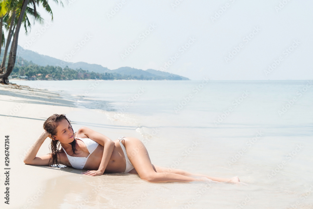 Young woman lying on a tropical white sand beach Young woman lying on a tropical white sand beach