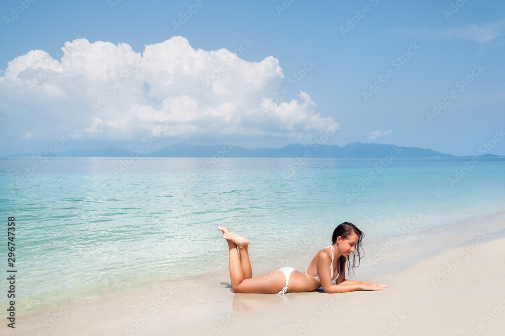 Young woman lying on a tropical white sand beach Young woman lying on a tropical white sand beach