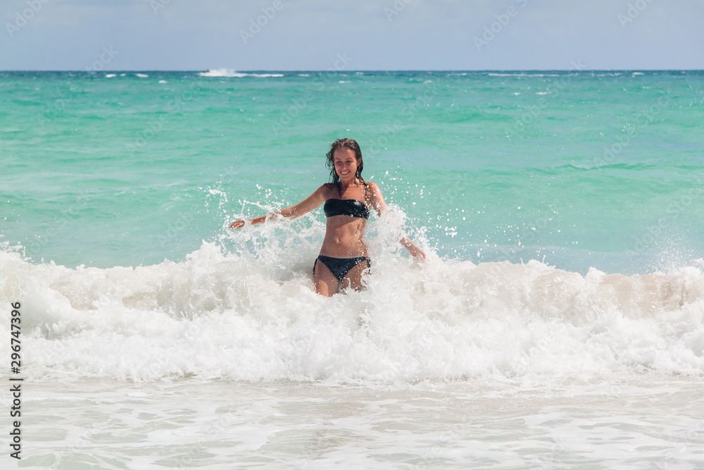 Young woman enjoying warm waves of a beautiful blue sea Young woman enjoying warm waves of a beautiful blue sea