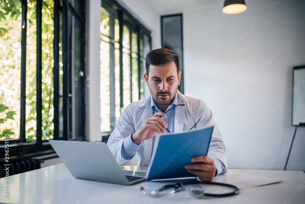 Portrait of a doctor doctor reviewing document in medical office. Portrait of a doctor doctor reviewing document in medical office.