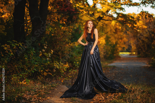 Beautiful young girl with long healthy hair, nice dress walking in the autumn forest