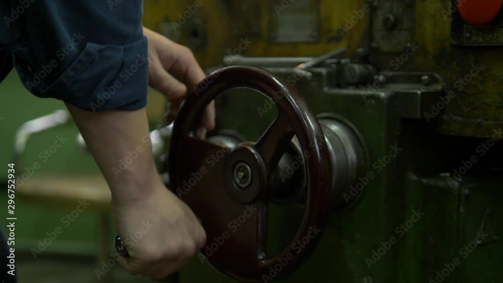 A factory worker is operating a heavy machinery on a plant. We ca see a lot of equipment at his work place. A factory worker is operating a heavy machinery on a plant. We ca see a lot of equipment at his work place.
