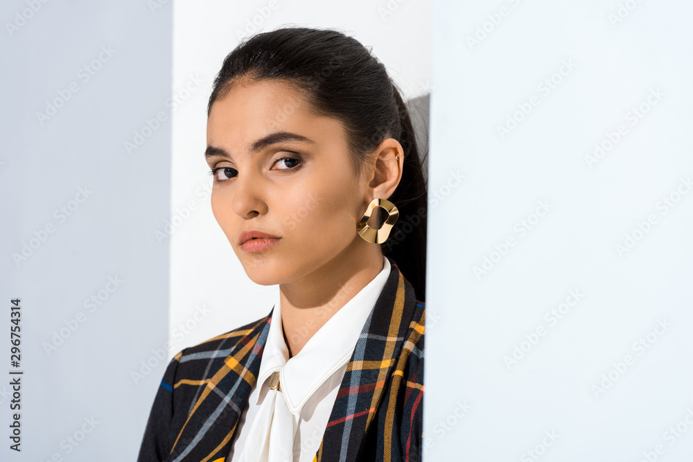 beautiful and young woman looking at camera on white and grey beautiful and young woman looking at camera on white and grey