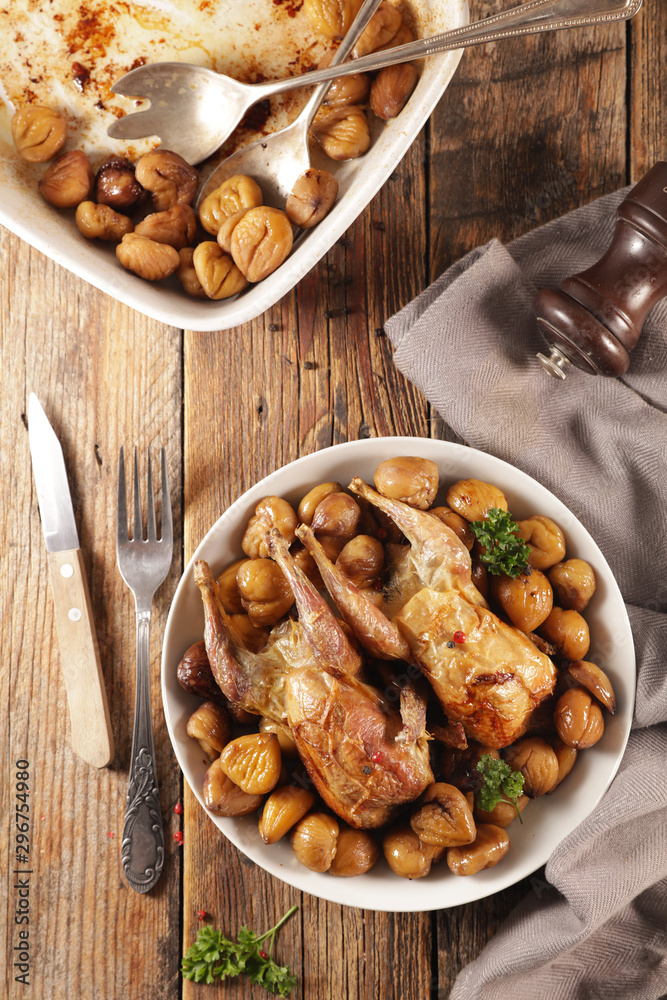 baked quail with chestnut- autumn dish on wood background baked quail with chestnut- autumn dish on wood background