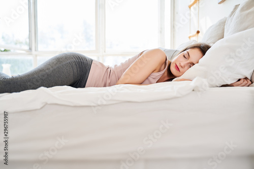 Photo of young woman sleeping on bed.