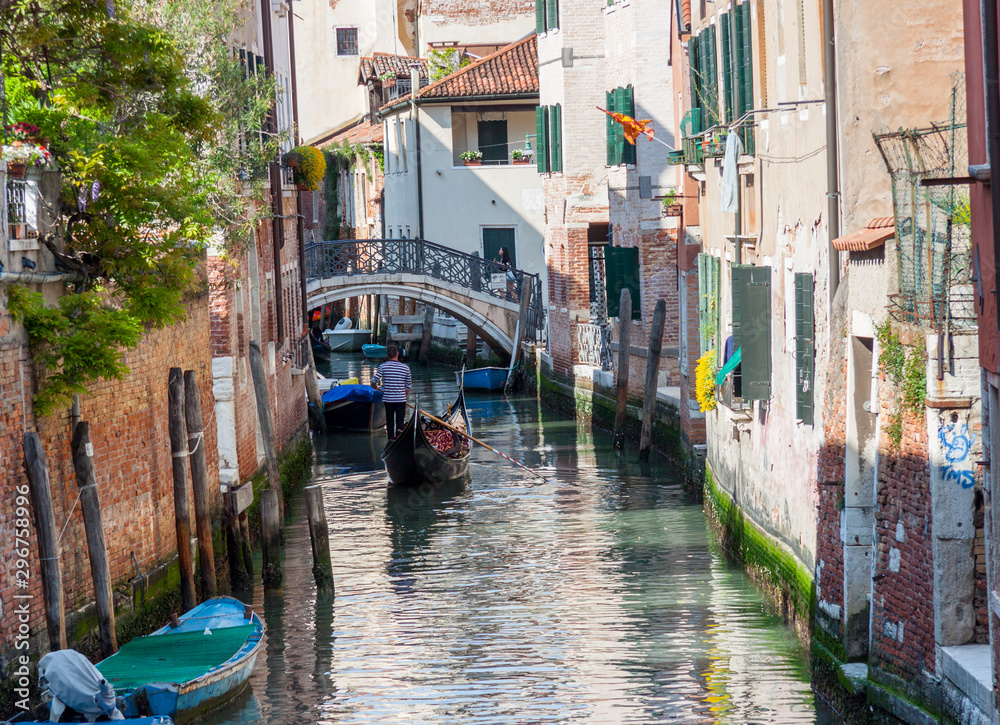 Tourists travel on gondolas at canal - Venice, Italy.