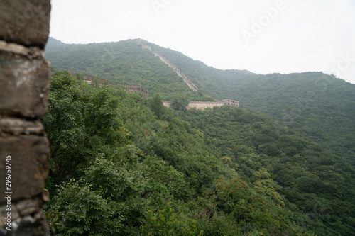 Great Wall of China with a green trees in a background. photo