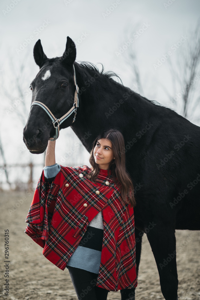 Obraz premium Girl with a horse at the stables
