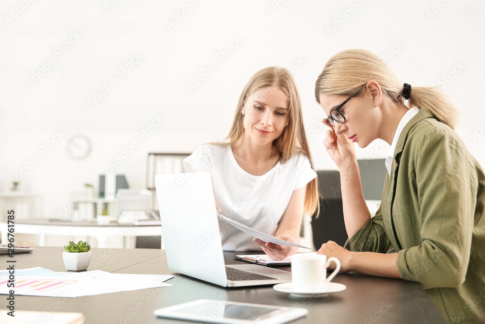 Beautiful businesswoman and her colleague discussing issue in office Beautiful businesswoman and her colleague discussing issue in office