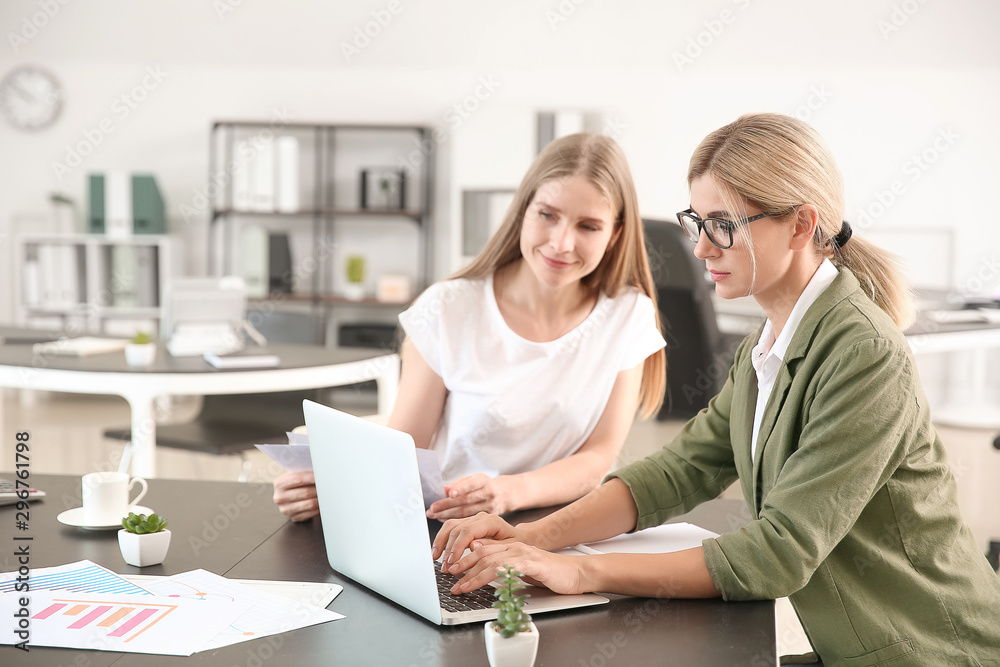 Beautiful businesswoman and her colleague discussing issue in office Beautiful businesswoman and her colleague discussing issue in office