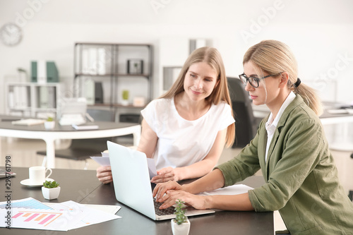 Beautiful businesswoman and her colleague discussing issue in office