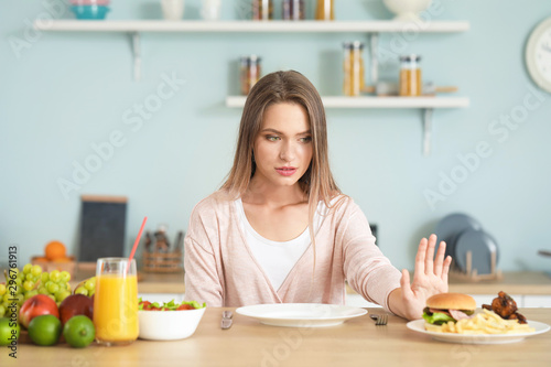Woman refusing to eat unhealthy food in kitchen. Diet concept © Pixel-Shot