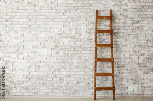 Wooden ladder near brick wall