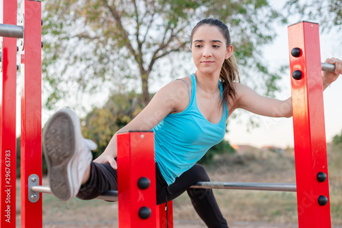 Young woman stretching her legs in an outdoor training park