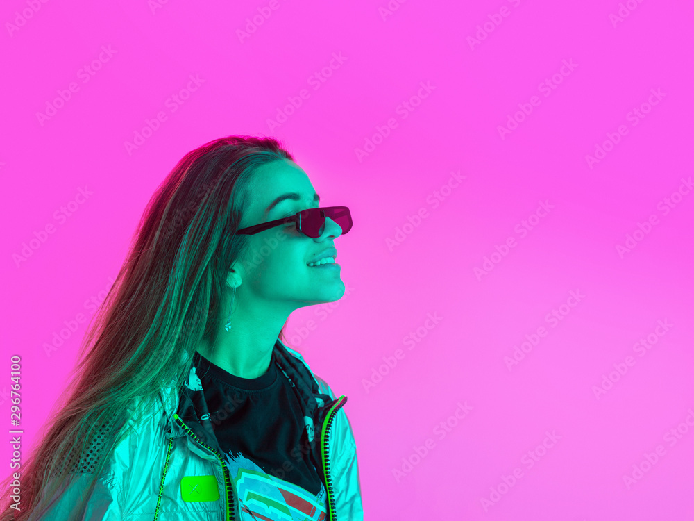 Young stylish girl dancing in the Studio on a colored neon background. Music poster design.