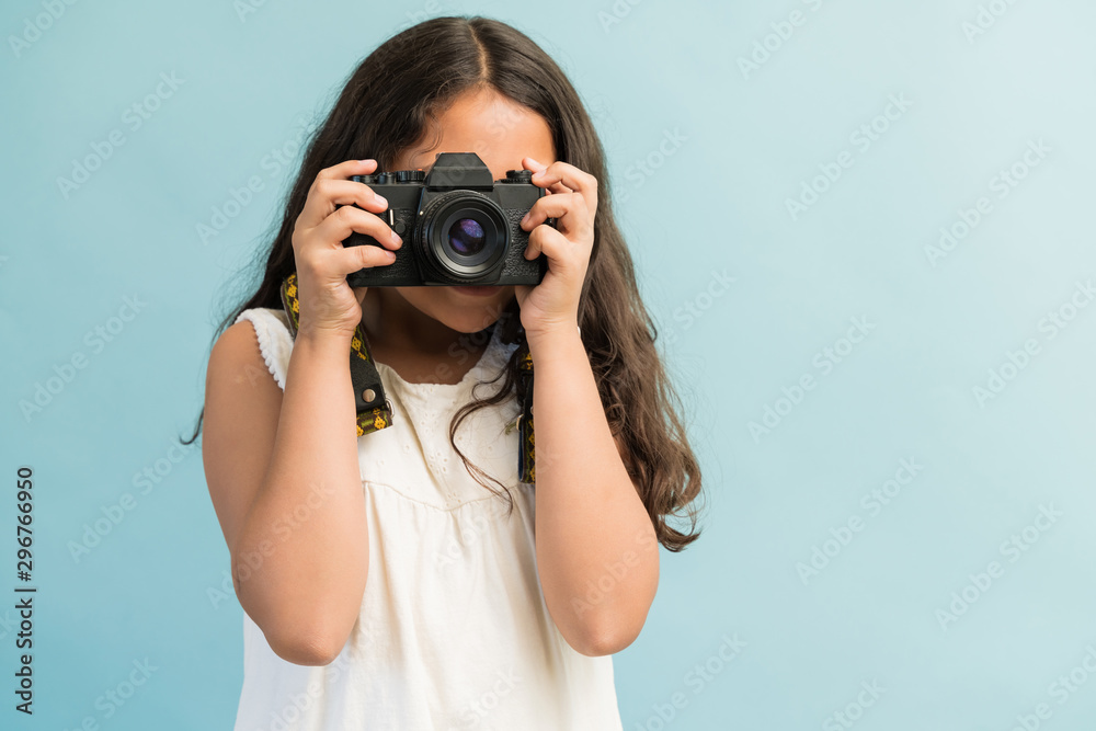 Hispanic Female Photographer Against Plain Background Hispanic Female Photographer Against Plain Background