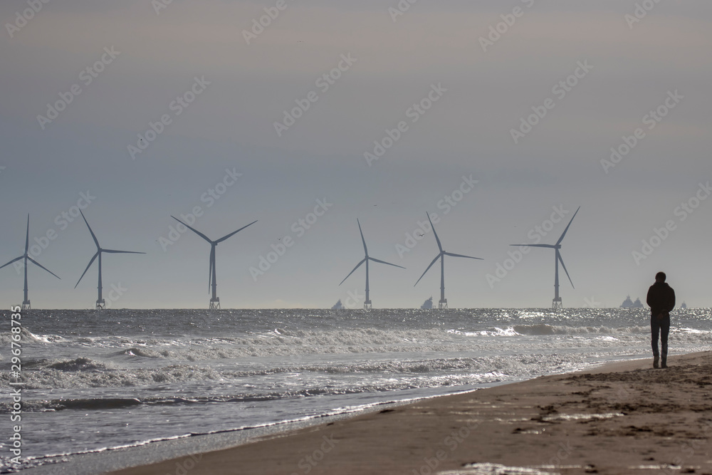 Off shore coastal wind farm near Aberdeen during a calm sunny October/autumn day with waves/people and sand in Scotland.