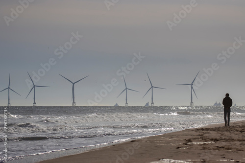 Obraz na płótnie Off shore coastal wind farm near Aberdeen during a calm sunny October/autumn day with waves/people and sand in Scotland. w salonie
