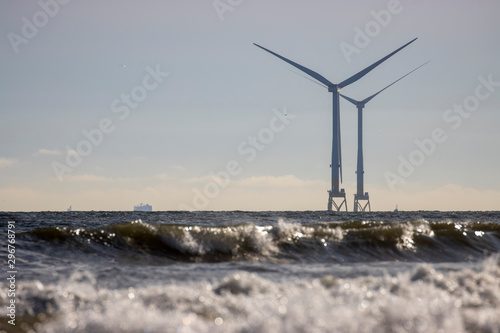 Off shore coastal wind farm near Aberdeen during a calm sunny October/autumn day with waves/people and sand in Scotland.