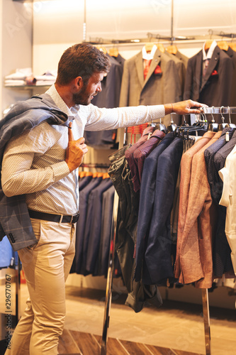 Elegant young man shopping in menswear