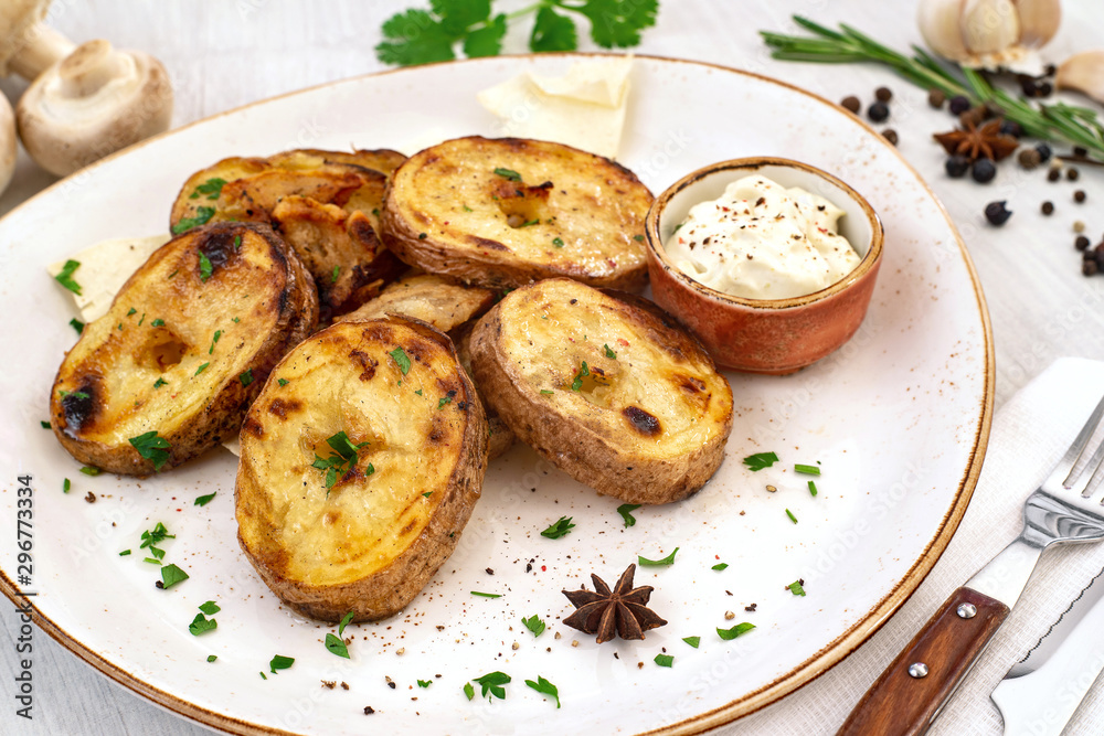 Rustic baked potato with cream sauce and spices on a serving platter. Copyspace Rustic baked potato with cream sauce and spices on a serving platter. Copyspace