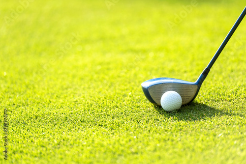Close up Golf club hitting golf ball along fairway towards green with copy space, green nature background. Lifestyle Concept.
