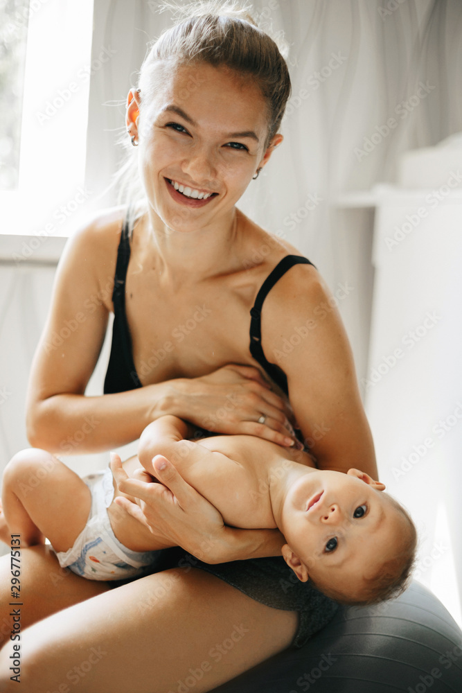Happy family laughing faces, mother holding adorable child baby boy, smiling and hugging, close up border, beauty of smile, healthy kid joyful mom, expressing love emotions Happy family laughing faces, mother holding adorable child baby boy, smiling and hugging, close up border, beauty of smile, healthy kid joyful mom, expressing love emotions