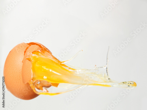 cracked egg with yolk on white background