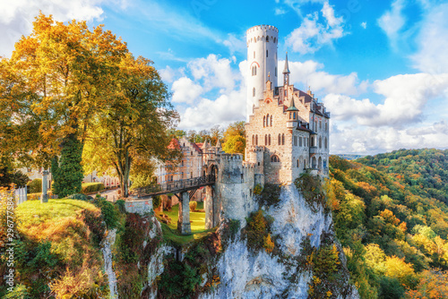 Germany, Lichtenstein Castle in Baden-Wurttemberg land in Swabian Alps. Seasonal view of Lichtenstein Castle on a cliff circled by trees with yellow foliage. European famous landmark.