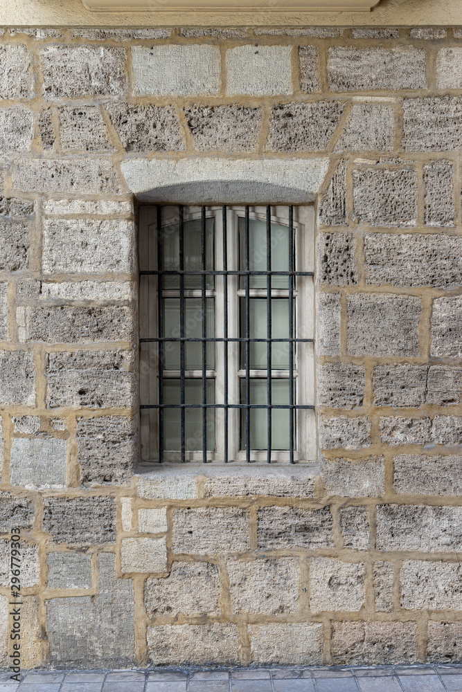 Vintage window with iron grating on a stone wall. Valencia, Spain