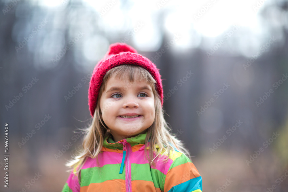 Kid girl in a red cap walk autumn day. Kid girl in a red cap walk autumn day.