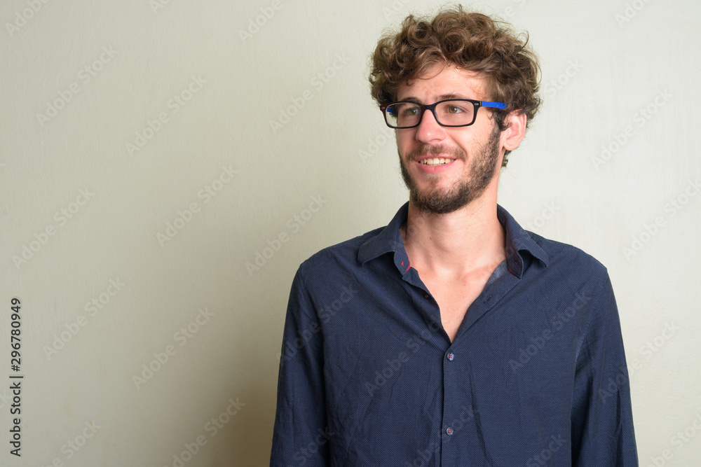 Obraz premium Face of happy young bearded businessman with eyeglasses thinking