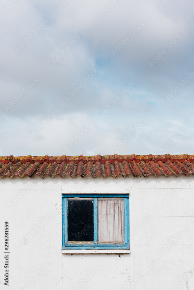 une fenêtre bleue sur un mur blanc avec le ciel. une fenêtre bleue sur un mur blanc avec le ciel.