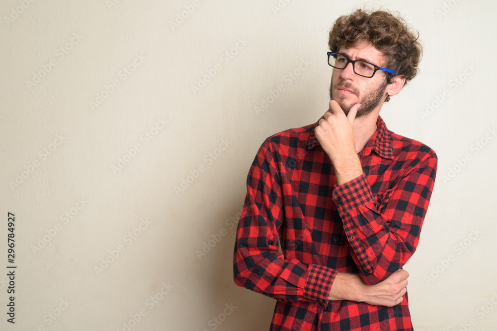Young bearded hipster man with curly hair thinking Young bearded hipster man with curly hair thinking