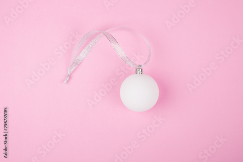 Christmas decoration on the Christmas tree white glass ball on a pink background, flat lay,copy space,minimalism concept,