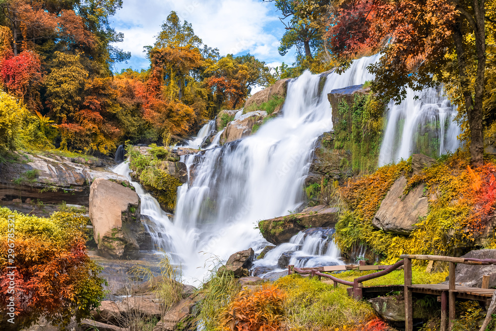 Colorful majestic waterfall in national park forest during autumn - obrazy, fototapety, plakaty 