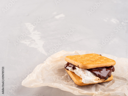 S'more on a gray surface with flowing chocolate.