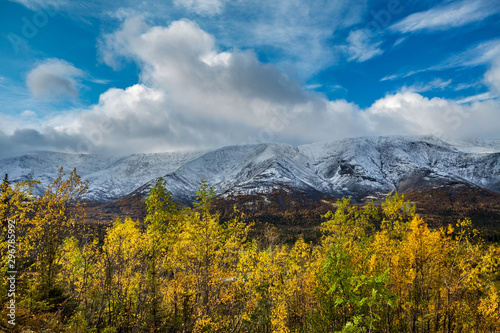 Mountain landscape. Rocky shore of a mountain lake on a rainy autumn day. First snow