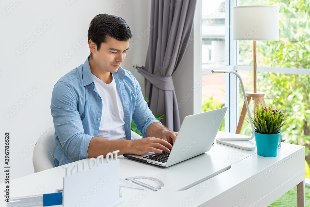 Attractive man is working at home using laptop computer notebook Attractive man is working at home using laptop computer notebook