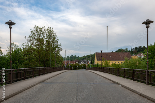 Fototapeta Naklejka Na Ścianę i Meble -  road with street lights and blue sky in small city Neudenau, Germany