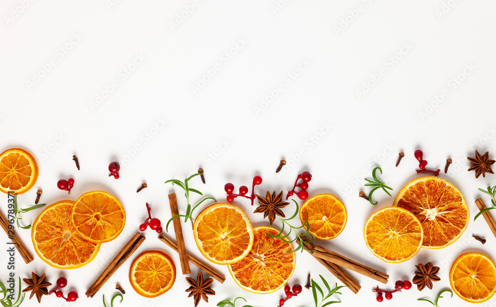  Christmas composition with dried oranges, cinnamon sticks and herbs on white background. Natural food ingredient for cooking or Christmas decor for home. Flat lay. - obrazy, fototapety, plakaty 