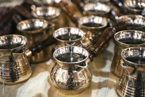Fototapeta Naklejka Na Ścianę i Meble -  Turkish copper coffee pots with ornaments on a counter in a Turkish bazaar