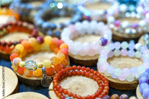 Variety of handmade beautiful stone bracelets on wooden stand