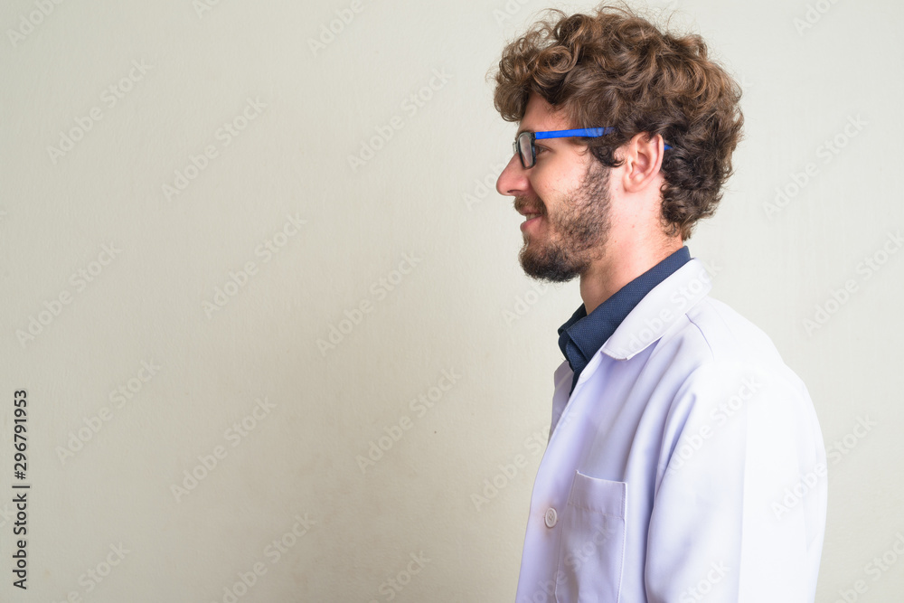 Closeup profile view of happy young bearded man doctor smiling Closeup profile view of happy young bearded man doctor smiling