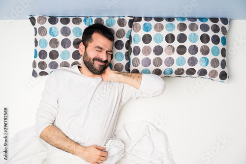 Man in bed in top view with neckache photo