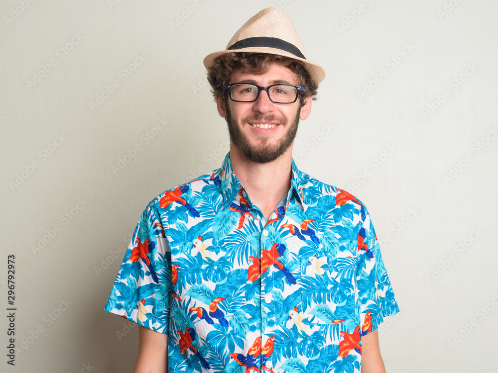 Face of happy young bearded tourist man smiling and ready for vacation