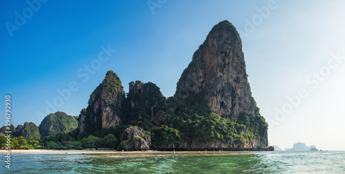 Phra Nang Cave Beach  Railay in Krabi province  Andaman sea. Picturesque sheer cliff hanging above water with swimming people and water splashing