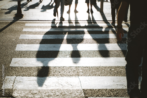 Pedestrian's shadow crossing the street on a sunny afternoon