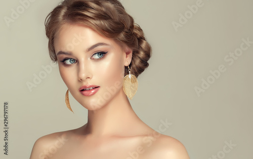 Beautiful model girl with elegant hairstyle and fashionable leaflet earrings . Woman with fashion  hair   and  accessories and jewelry ..